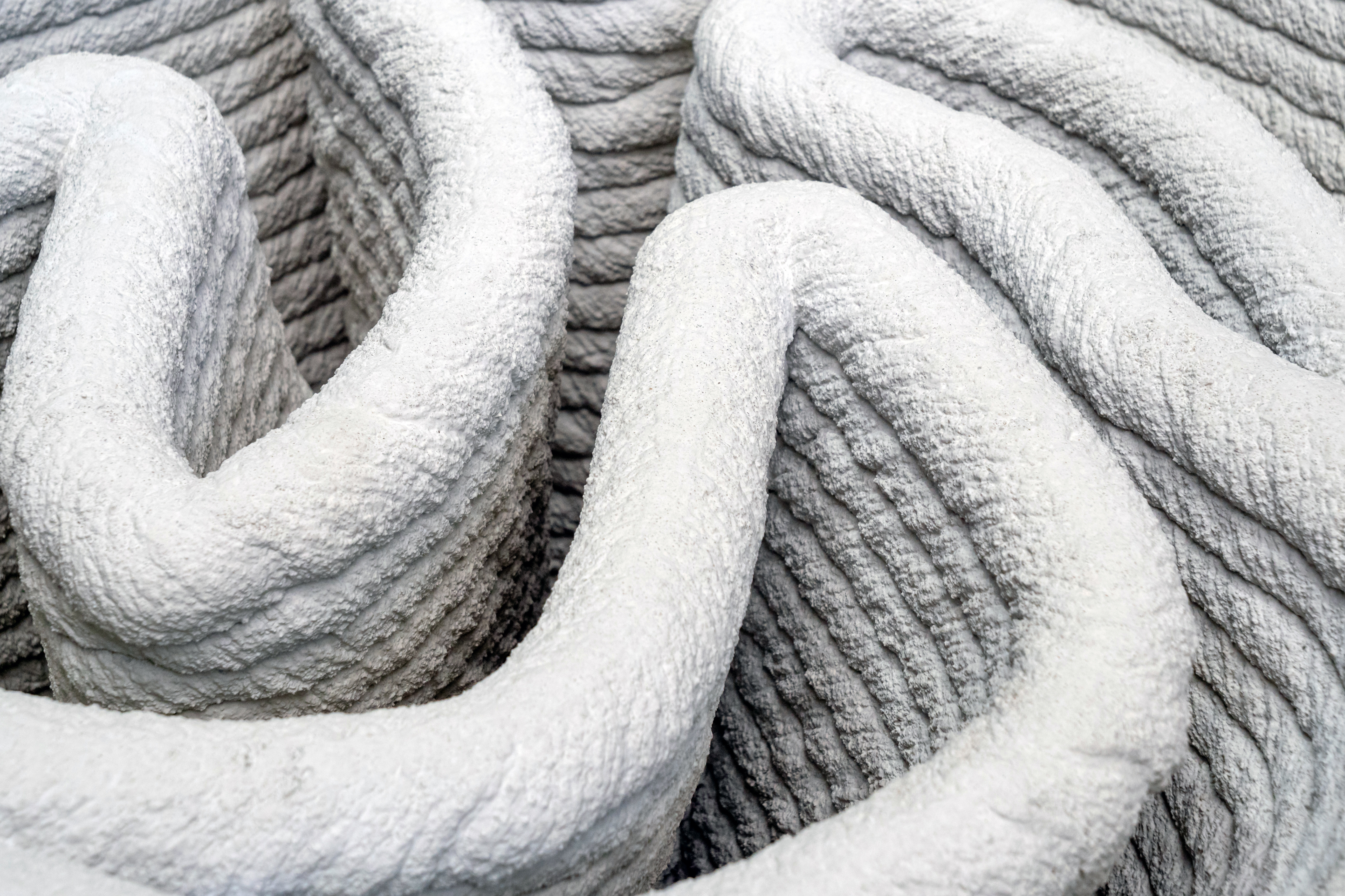 Close-up of coiled white rope with textured surface and curved organic forms