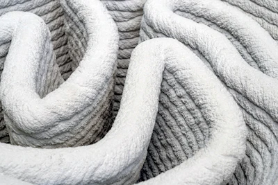 Close-up of coiled white rope with textured surface and curved organic forms