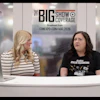 Two women at a broadcast desk during The Big Show coverage event with CAT and construction industry branding visible in background