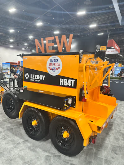 Yellow Leeboy HB4T asphalt paver with 'I Make America' branding displayed at industrial trade show