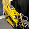 Yellow Caterpillar compact track loader on display in showroom with black curtain backdrop