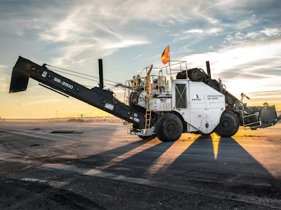 ROADTEC asphalt paving machine operating on a road at sunset with dramatic sky