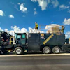 MacPower industrial vacuum truck on highway with clear sky and grassland background