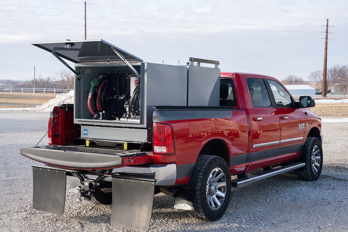 Red pickup truck with open emergency equipment compartment and metal storage boxes mounted on rear