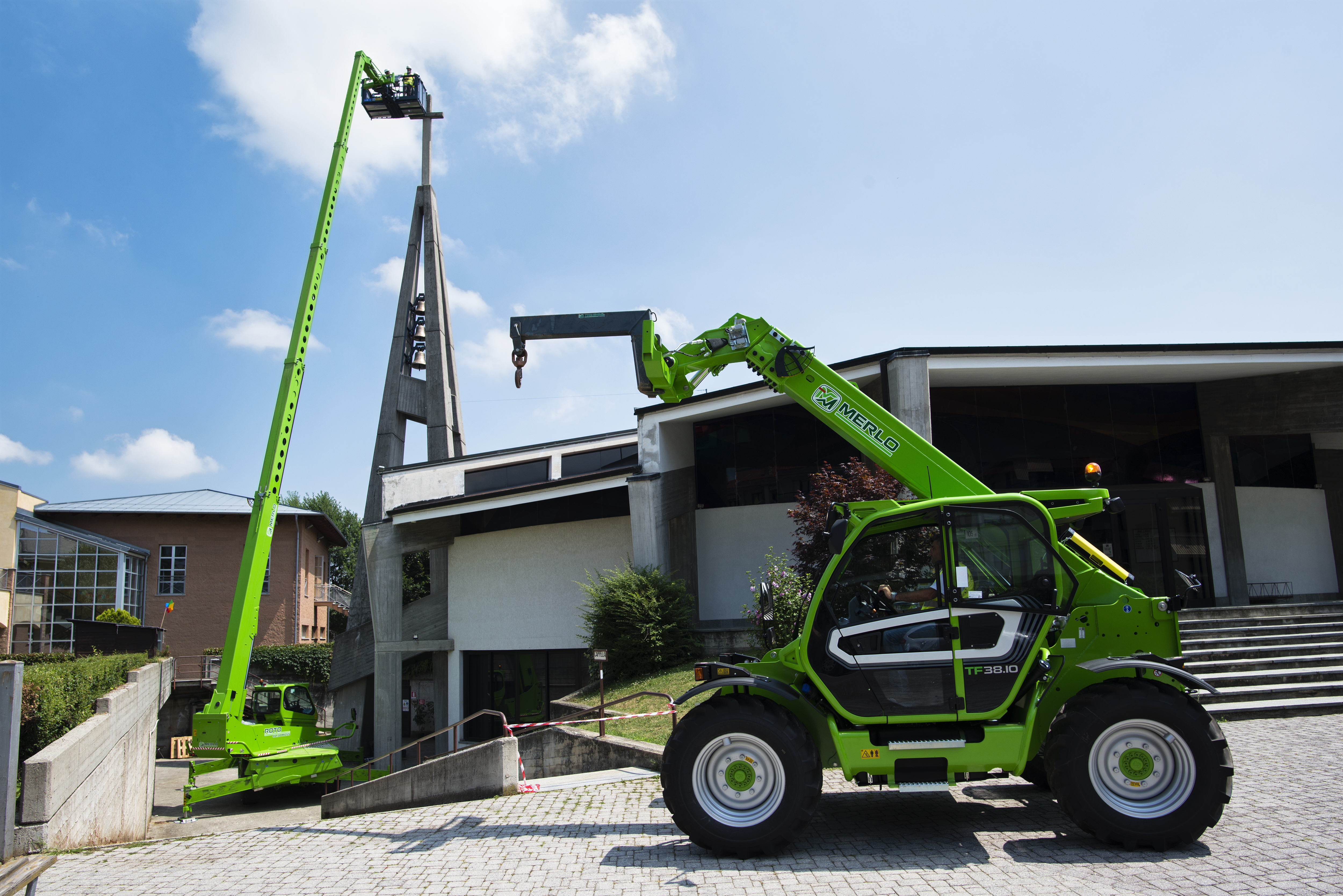 Bright green Merlo telehandler with extended boom positioned outside modern industrial building