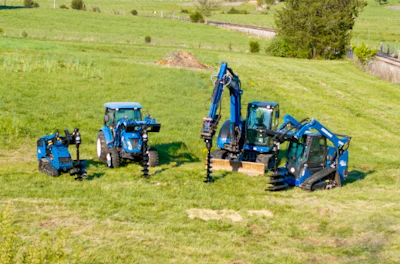 Blue agricultural machinery including excavator and tractors operating in a green hillside field