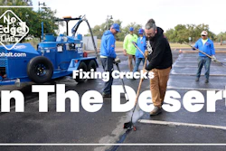 Asphalt repair crew filling cracks in desert parking lot with blue equipment and workers