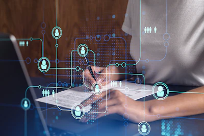 Digital network visualization with interconnected user icons and connection nodes overlaid on hands using a tablet device