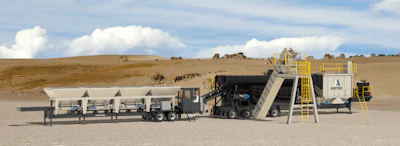 Mobile asphalt mixing plant and paving equipment on construction site with desert landscape