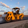 Yellow tandem asphalt roller compacting fresh pavement on a rural road with cornfields and cloudy sky in background