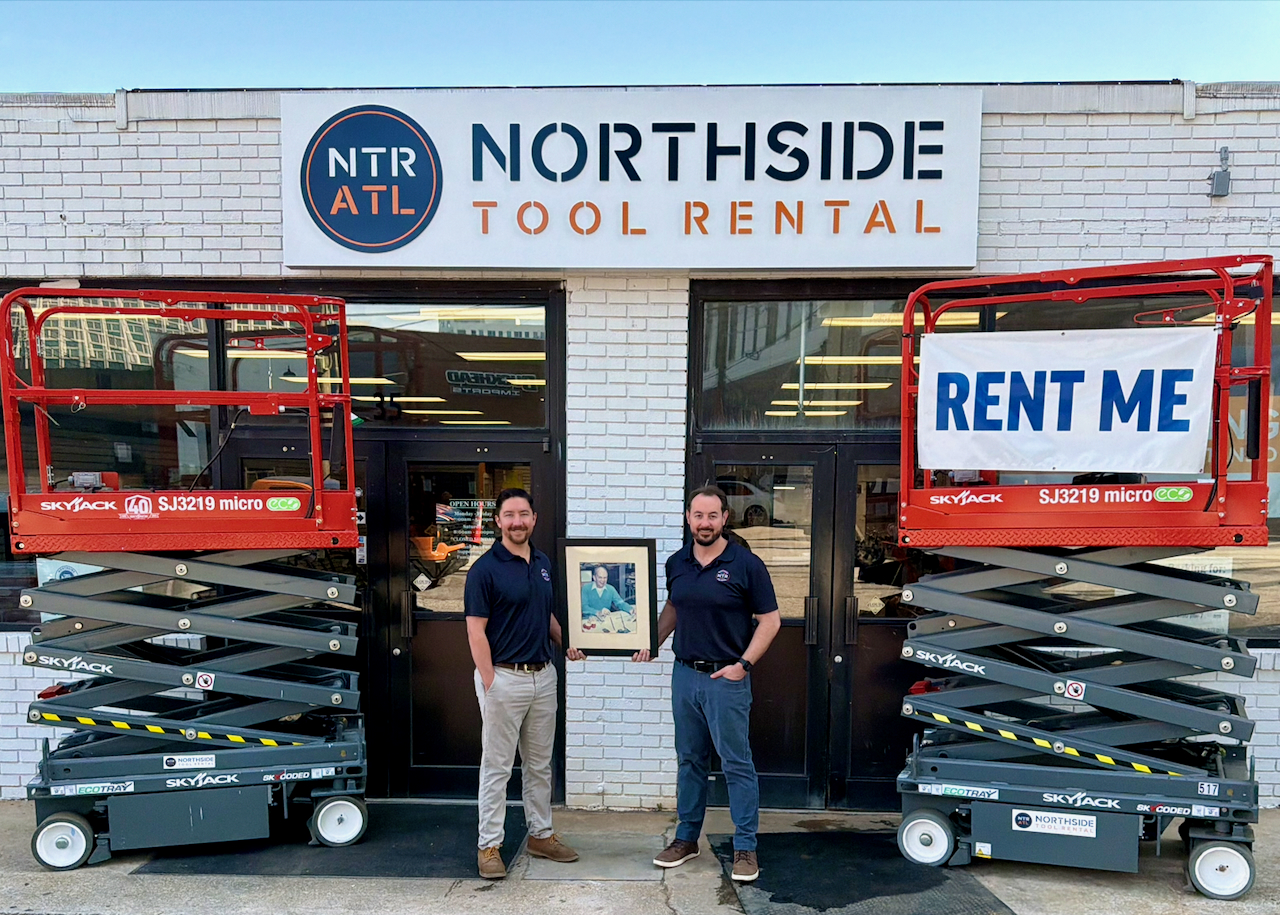 Northside Tool Rental storefront with two employees standing between red scissor lifts and 'Rent Me' signage