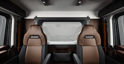 Mack Trucks cabin interior with brown leather seats featuring Mack branding and large windshield