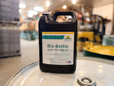 Black industrial jug of Bio-Bottle Jack Oil ISO 32 with teal and yellow label in warehouse setting