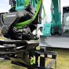 Steelwrist rotating coupling attachment on display with heavy construction equipment and machinery in background