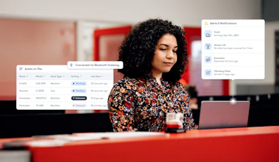 Professional woman working at desk with laptop, surrounded by asset management and notification interface windows in modern office setting