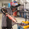 Welder in protective gear performing metal welding with sparks in an industrial workshop