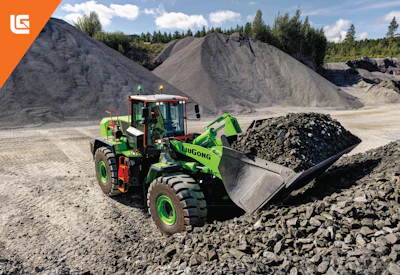 Bright green LiuGong wheel loader moving aggregate materials at a quarry with large gravel piles and forested hills in background
