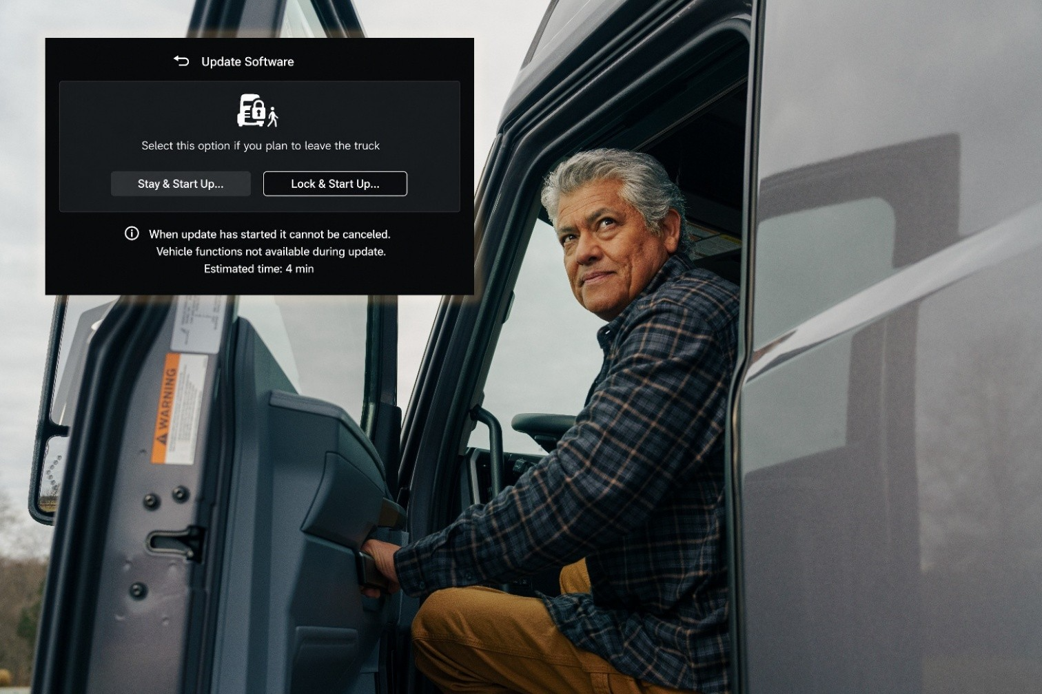 Truck driver in cab with software update dialog displaying stay and start up or lock and start up options