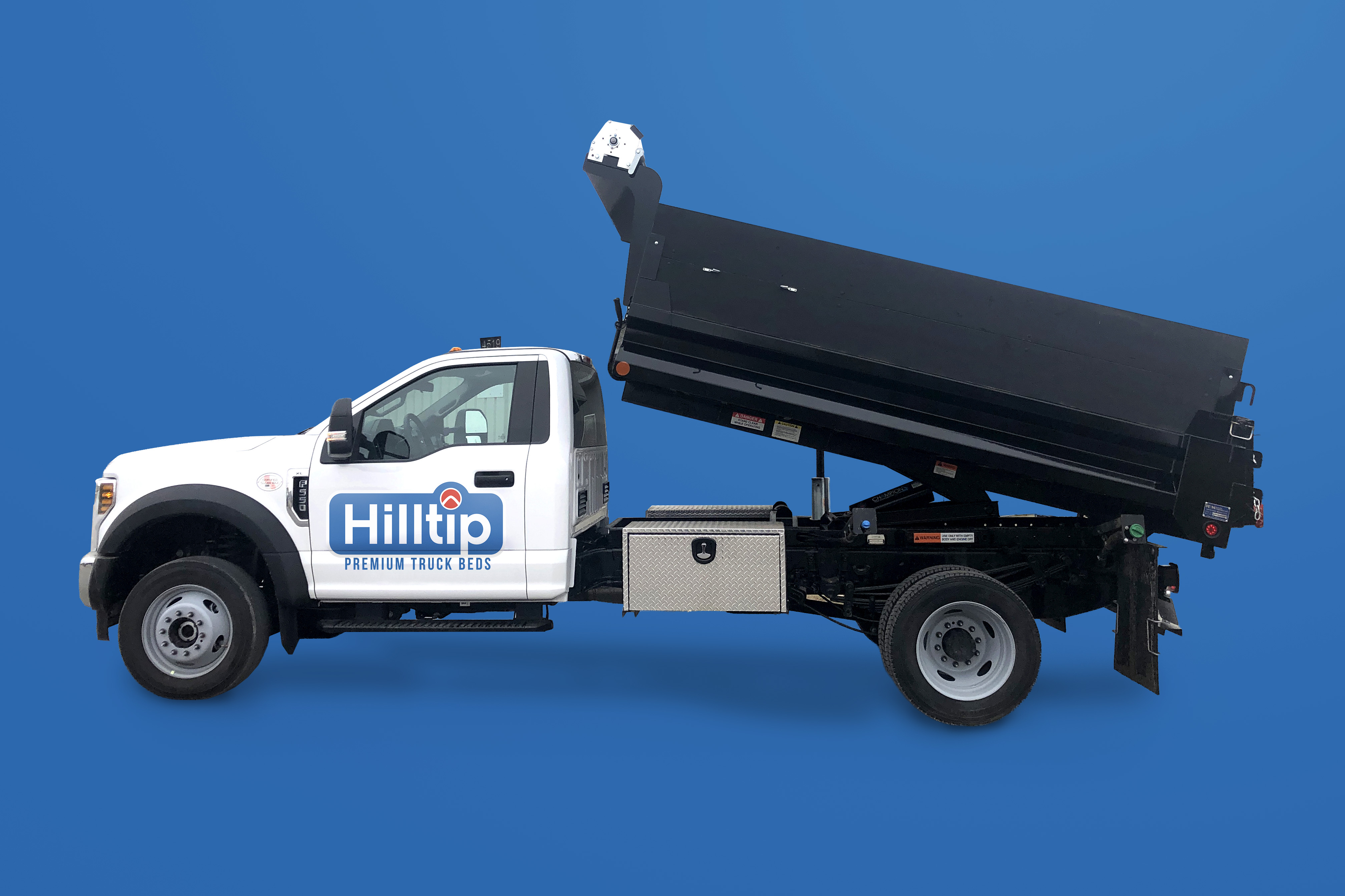 White Hilltip dump truck with raised black bed against blue background