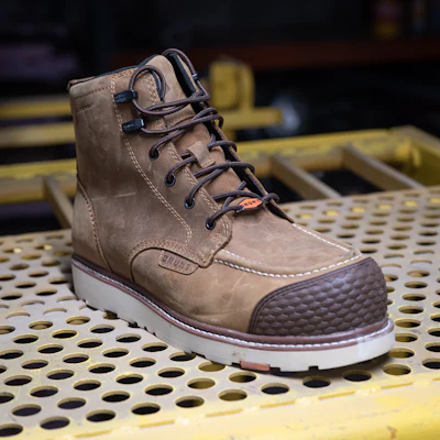 Tan leather work boot with navy laces and white sole on yellow perforated metal platform