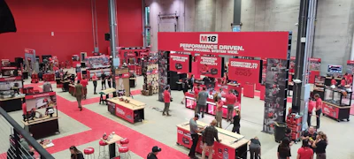 M18 brand exhibition booth with red and white signage, multiple display stations, and visitors at a trade show or promotional event