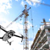Drone flying over construction site with tower crane and partially built residential building against blue sky