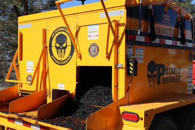 Yellow and orange pothole repair machine with skull logo and 'Pothole Punisher' branding