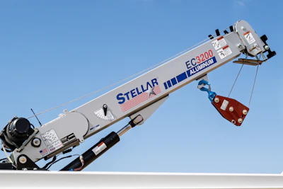 Stellar FC3200 aluminum truck-mounted crane with blue boom against clear sky