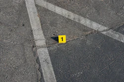Yellow evidence marker numbered 1 on asphalt with white painted lines
