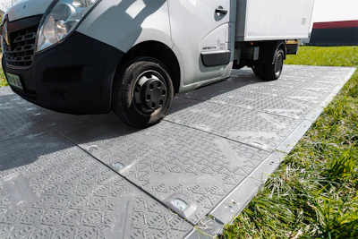 White commercial delivery van parked on textured paving with grass border