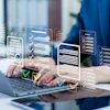 Professional in blue suit using laptop with holographic checklist and task management interfaces floating above keyboard