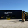 Five Star Equipment dealership with yellow excavators parked outside black warehouse building under clear sky
