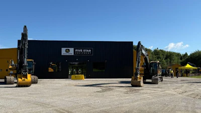 Five Star Equipment dealership with yellow excavators parked outside black warehouse building under clear sky