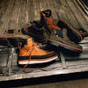 Orange and black work boots with safety gear arranged in a truck bed