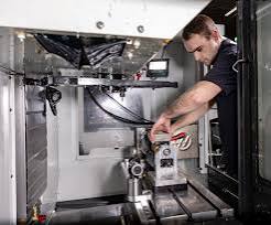 Technician working inside a 3D printer or industrial equipment chamber