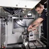 Technician working inside a 3D printer or industrial equipment chamber