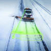 Snow plow truck clearing a snow-covered highway with neon green operational visualization overlay during winter weather.