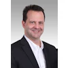 Professional headshot of a man in business attire smiling at the camera
