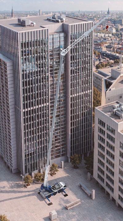 Modern skyscraper with vertical ribbed facade and construction crane against urban cityscape skyline